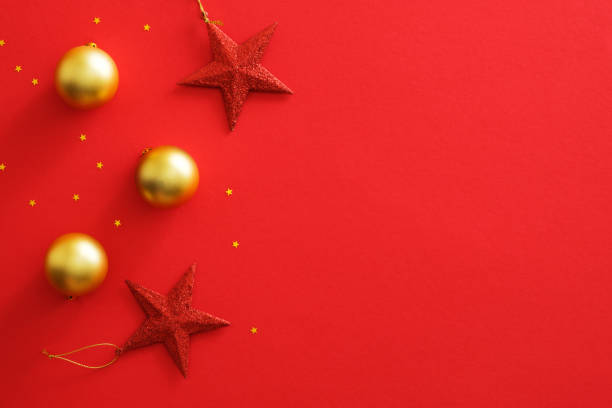 istock Christmas ornaments decorations on red background with copy space. Flat lay golden baubles balls, red stars, glitter confetti. Christmas flyer mockup, greeting card template, website hero banner 1172826963