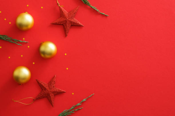 istock Christmas ornaments decorations on red background with copy space. Flat lay golden baubles balls, red stars, glitter confetti, fir branches. Christmas cover mockup, greeting card template. 1172826968