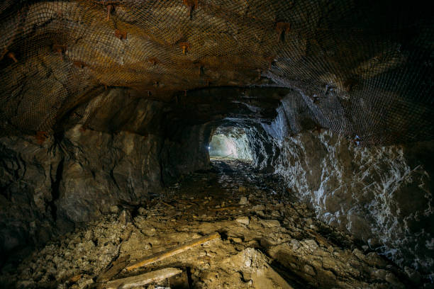 Dark dirty abandoned uranium mine with rusty remnants of railway