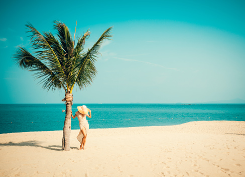 Woman in sunhat at tropical beach