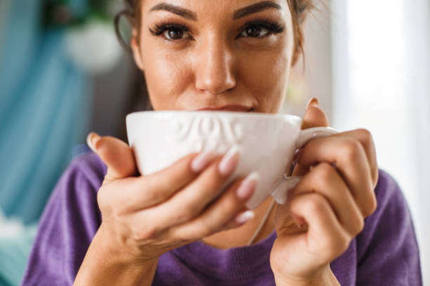 istock Young woman enjoying while drinking fresh tea from beautiful china cup 1172836759