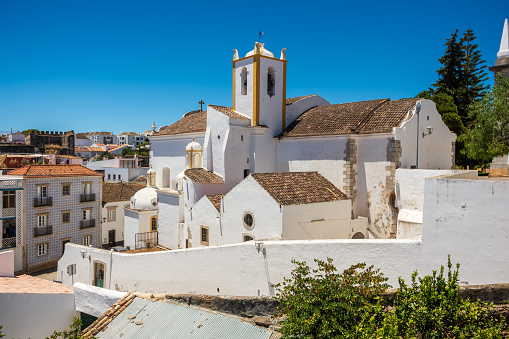 The whitewashed Santiago Church or Igreja de Santiago is located near the castle in the picturesque town of Tavira, Portugal. Originally built in the mid 13th century, the church was rebuilt in the 17th century due to earthquake damage.