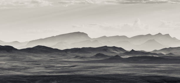 Montana Panoramic Rocky Mountains Black and white photograph landscape scenic of Montana Rocky Mountains in distance under a dreamy cloudy sky, No people in this image with horizontal composition. foothills photos stock pictures, royalty-free photos & images