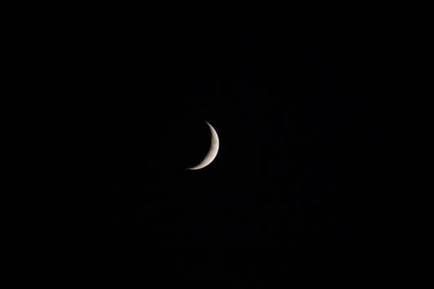 istock Small slither of moon against a black night 1172844189