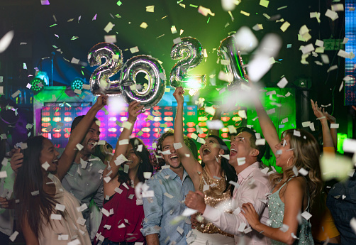 Happy group of people celebrating the New Year 2021 at a nightclub and having fun partying