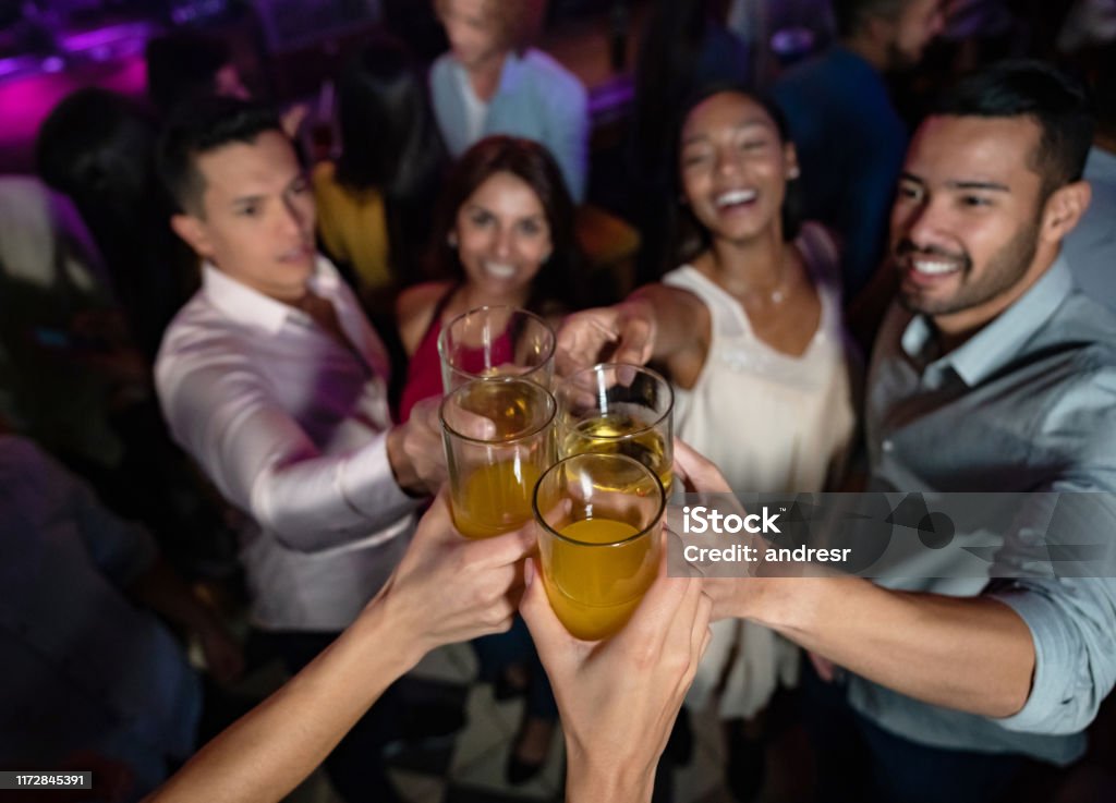 Happy group of friends at the nightclub making a toast Portrait of a happy group of friends at the nightclub making a toast at the dance floor - lifestyle concepts Bar - Drink Establishment Stock Photo