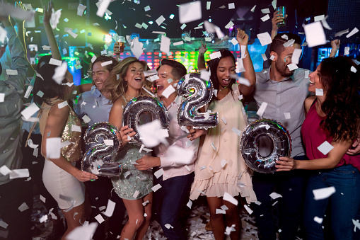 Happy group of people celebrating the New Year 2020 at a nightclub â lifestyle concepts