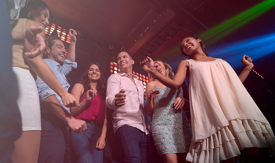 Happy group of friends on the dance floor having fun while celebrating a birthday - lifestyle concepts