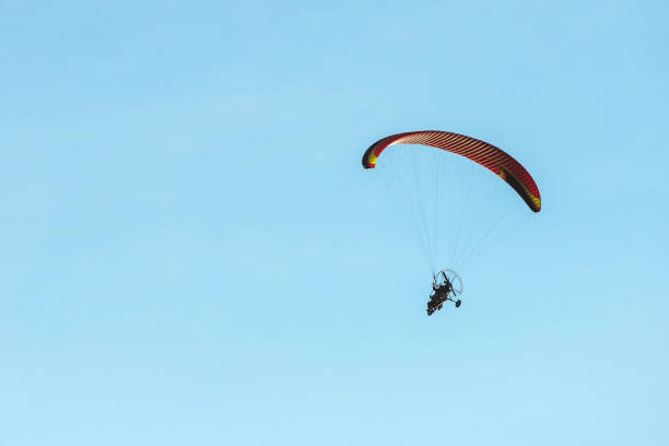 istock bright paraglider with a motor flies in the blue sky 1172845580