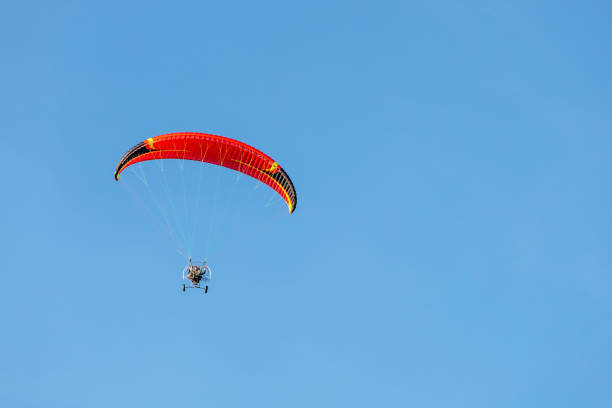 istock bright paraglider with a motor flies in the blue sky 1172845581