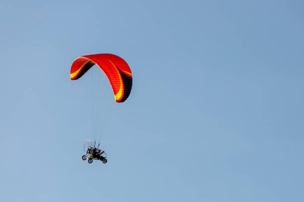 istock bright paraglider with a motor flies in the blue sky 1172845582