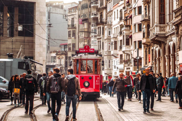 rote straßenbahn auf der überfüllten istiklal avenue in taksim, istanbul - beyoglu fotos stock-fotos und bilder