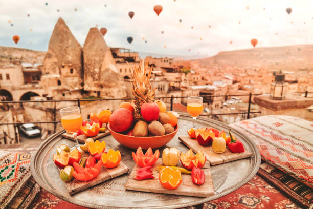 путешествие в каппадокии красочные воздушные шары пролетел над долиной восхода времени со специальным местом путешествия завтрак в турци� - cappadocia hot air balloon turkey basket стоковые фото и изображения