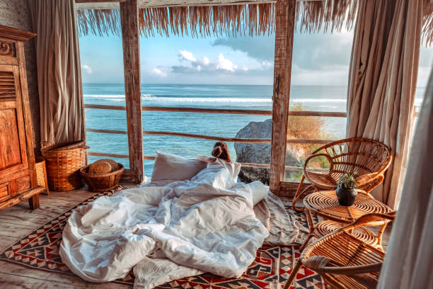 donna che si gode le vacanze mattutine su un bungalow sulla spiaggia tropicale con vista sull'oceano vacanza rilassante a uluwatu bali, indonesia - bali foto e immagini stock