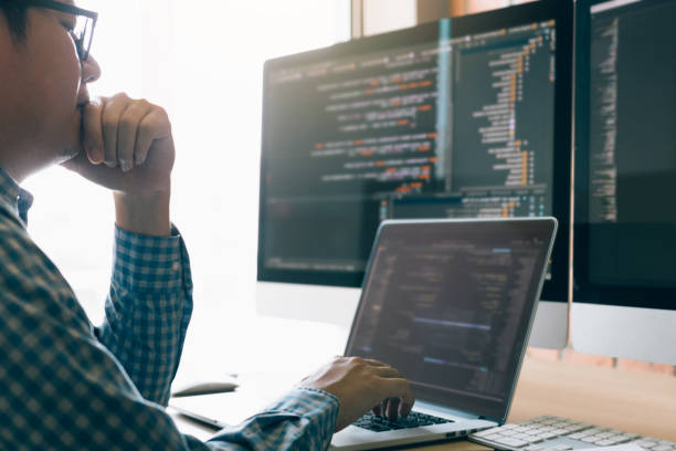 les programmeurs d'homme sont stressés et le nez de fixation de main avec le mal de tête au bureau tout en travaillant l'analyse sur le bureau dans le code à la salle de bureau. - computer network order design engineer photos et images de collection