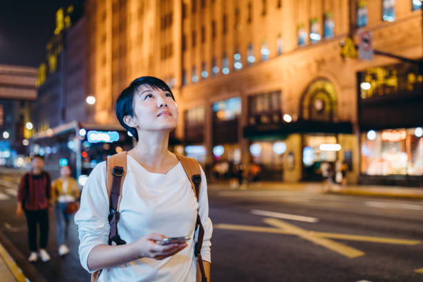 istock Asian young woman using smart phone at street. 1172850346