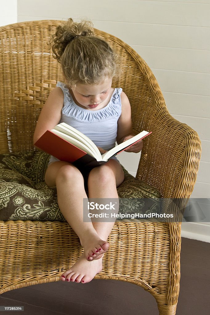 Child reading Little girl reading book. Barefoot Stock Photo