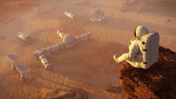 istock astronaut on planet Mars, sitting on a cliff above a research station  (3d space rendering) 1172857112