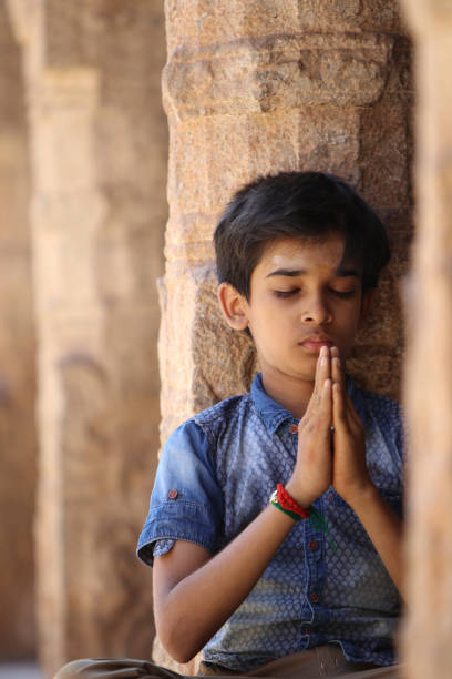 istock Indian young boy meditating at hindu temple 1172857177