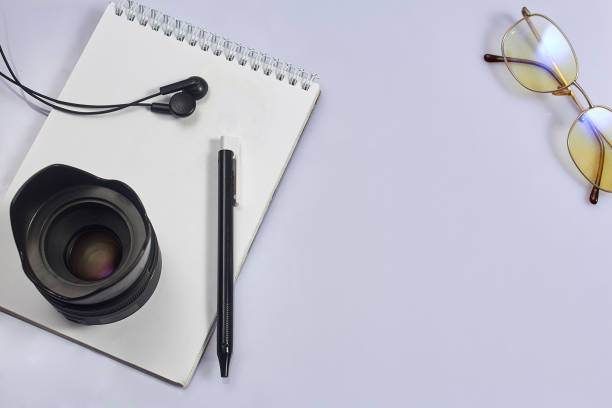 istock White photographer's Desk with notebook, lens, pen, glasses. 1172876954