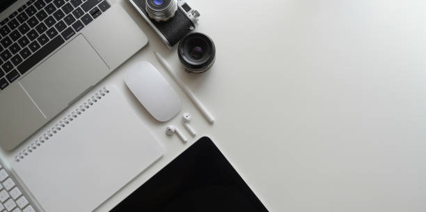 istock Overhead shot of modern workplace with laptop computer, tablet, office supplies on white table background with copy space 1172881149