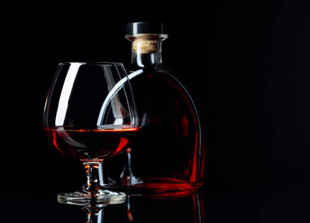 istock Glass and bottle of brandy on a black reflective background. 1172881240