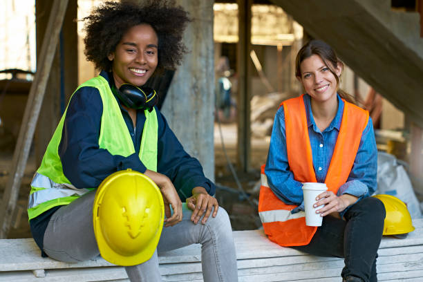 Female engineer holding coffee by coworker