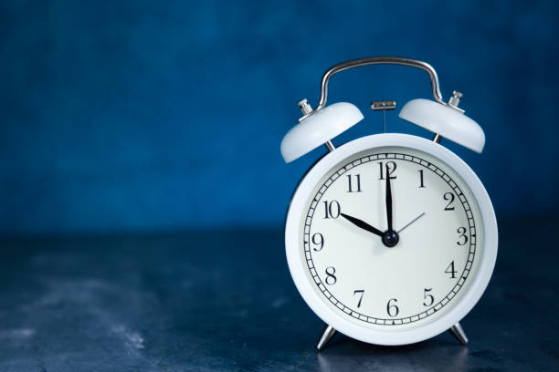 white vintage alarm clock 10:00 o´clock close-up