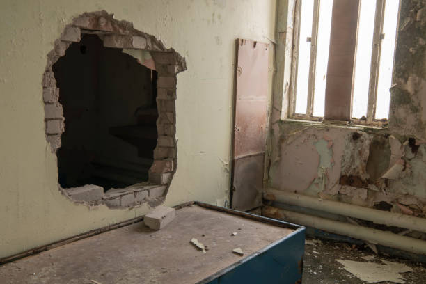 Hole punched through the wall of a prison cell for an escape. Hole punched through the wall of a prison cell for an escape. prison escape stock pictures, royalty-free photos & images