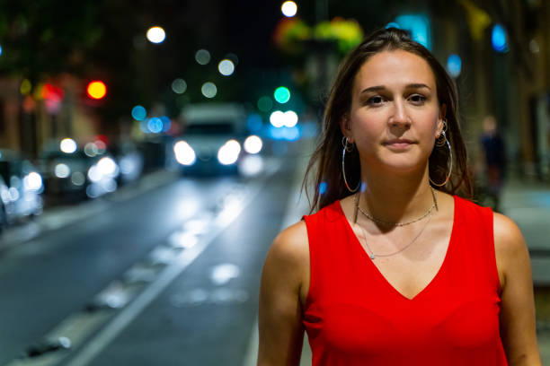 Young woman walking in a city street at night stock photo