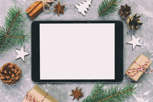 istock Digital tablet mock up with rustic Christmas gray cement background decorations for app presentation. top view with copy space. Toned 1172897231