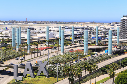 Los Angeles, California, USA - May 22, 2019: View of the Los Angeles International Airport. Captured from above. LAX-Entrance sign in the foregrund. In the back are the pylons.