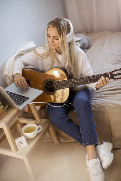 istock Girl Playing Guitar at Home 1172900171
