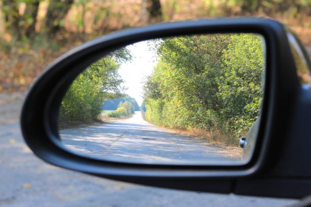 istock Car mirror with image of summer forest in reflection in good clear weather 1172901018