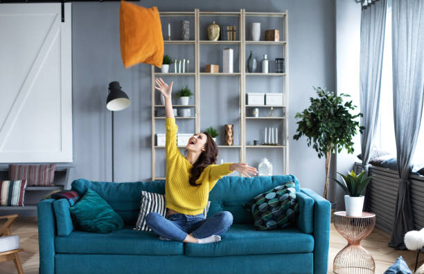 istock Happy woman sitting on the sofa sitting down with pillow. 1172903328