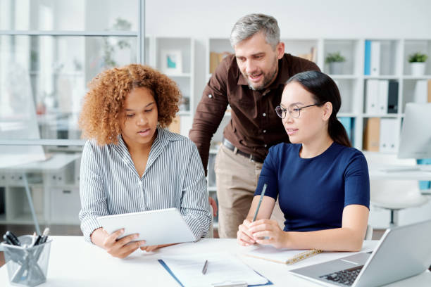 istock Group of young contemporary confident office workers working over presentation 1172904631