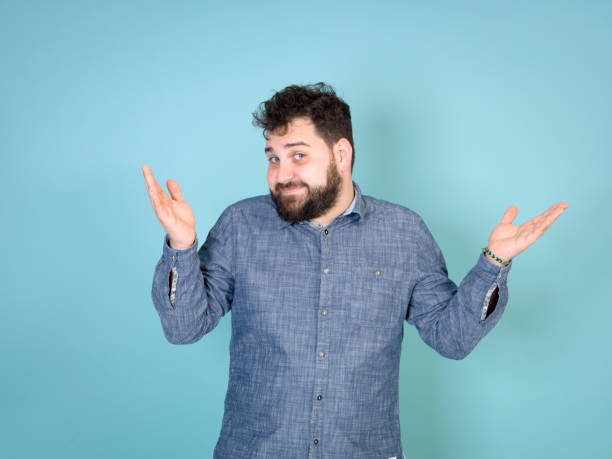 istock cool and young man posing in front of blue background with copy space 1172904782