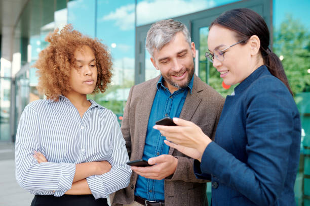 istock Two young employees with smartphones looking through message history 1172904859