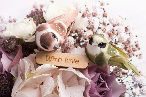 Shabby chic hydrangea bouquet closeup with wooden sign With Love and two birds