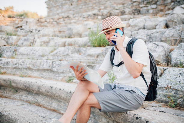 istock Man is exploring Ephesus with map while talking on the phone 1172910800