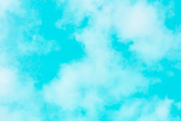 Abstract background texture of a vibrant teal blue sky with soft clouds
