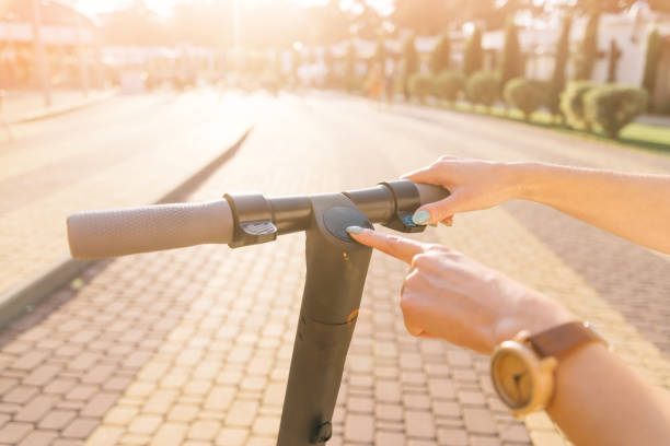 電動スクーターのオン/オフを切り取る女性の手のビュー。 - on wheels 写真 ストックフォトと画像