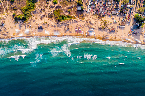 Aerial drone view of a crowded beach umbrellas bars and people on the summer sand. The location is Smokinya beach near Sozopol, Bulgaria on Black Sea in Eastern Europe. The photo is taken with DJI Phantom 4 Pro drone.