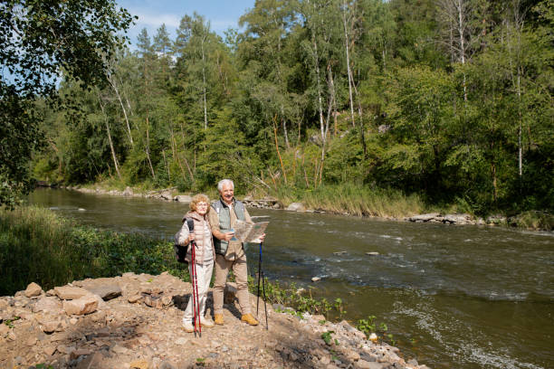 istock Senior couple with map standing by forest river while going to find way back 1172918089
