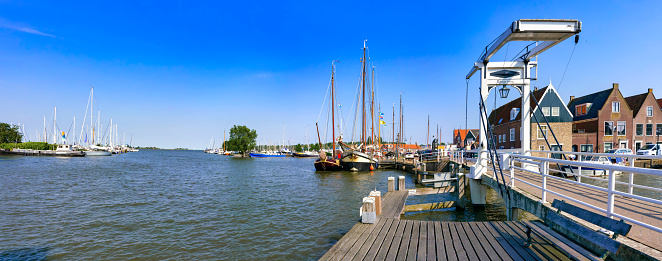 Monnickendam, Netherlands, 06/22/2019: The Langebrug with the marina in the background under a blue sky. Waterland district