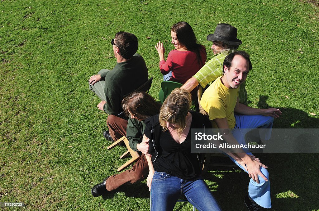 musical chairs Six friends playing the game musical chairs - two are trying to fit on one chair, and another is falling off his little chair. Chair Stock Photo