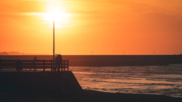 istock couple taking self-portrait on the beach at sunset 1172935340