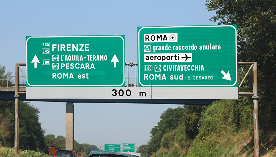 Road junction on italian highway with directions to Rome or Florence in Italy