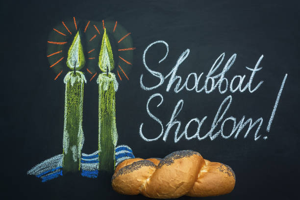 Shabbat Shalom - Jewish and Hebrew greetings. Candles painted on a chalkboard. May you dwell in completeness on this seventh day. stock photo