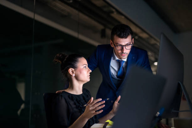 istock Young business people in an office at night, using computer. 1172944268